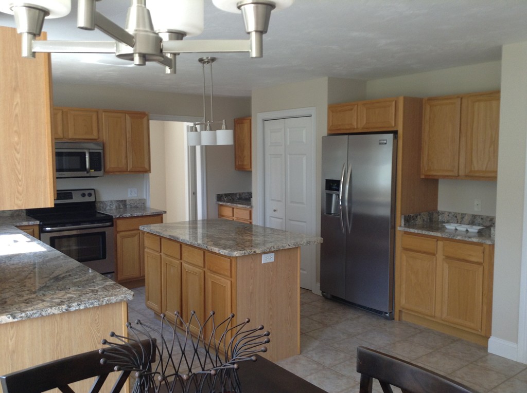 91 Haggerty Road Charlton, MA 01507 - Photo 3 of 15 a kitchen with granite countertop kitchen island stainless steel appliances a refrigerator a stove a sink and a center island