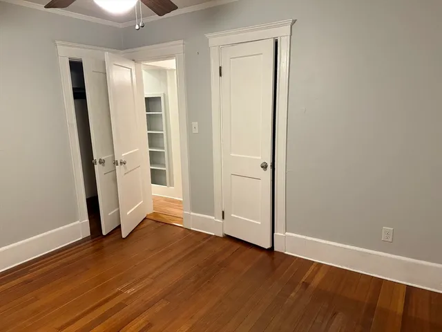 an empty room with wooden floor and entrance