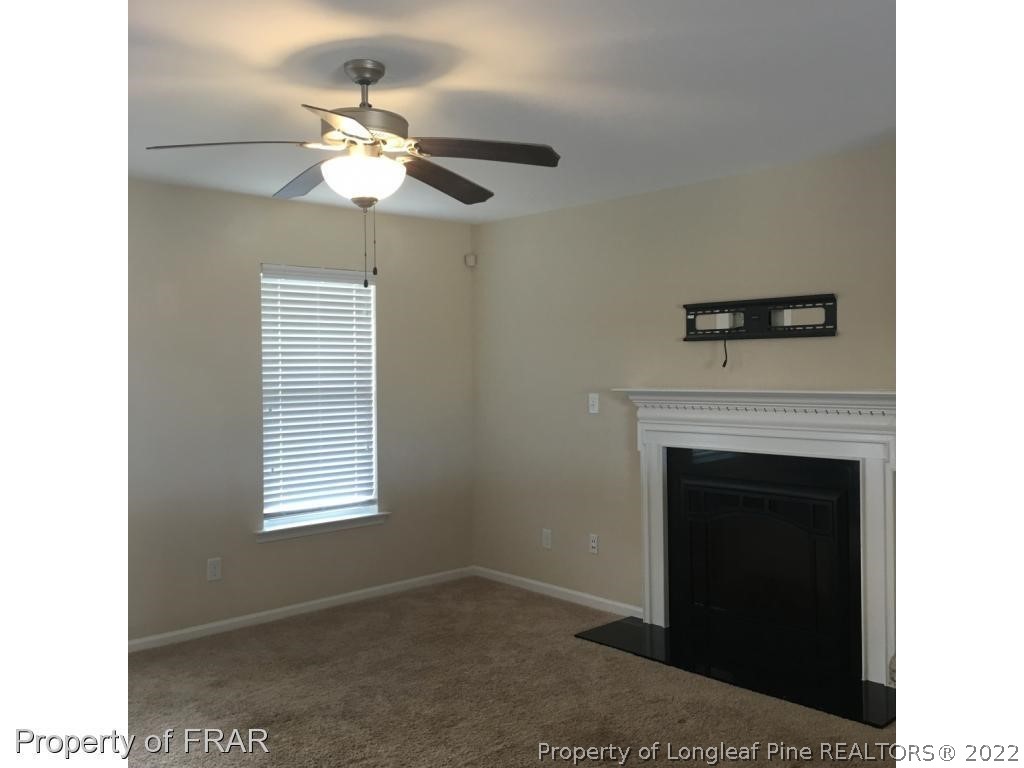 434 New Castle Lane Spring Lake, NC 28390 - Photo 3 of 12 a living room with a fireplace and a ceiling fan