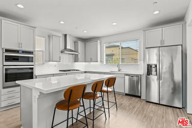 a kitchen with stainless steel appliances granite countertop a stove refrigerator sink and cabinets