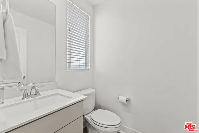 a bathroom with a sink toilet and mirror