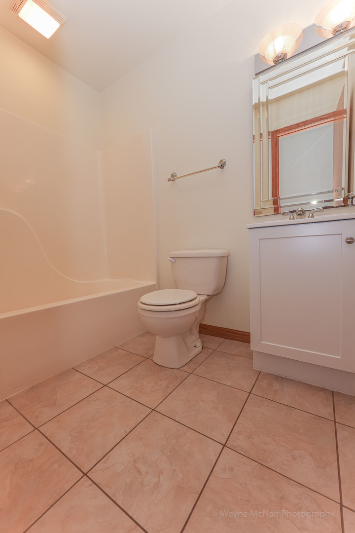 206 1/2 Redbud Drive Joliet, IL 60433 - Photo 19 of 34 a bathroom with a toilet and a mirror