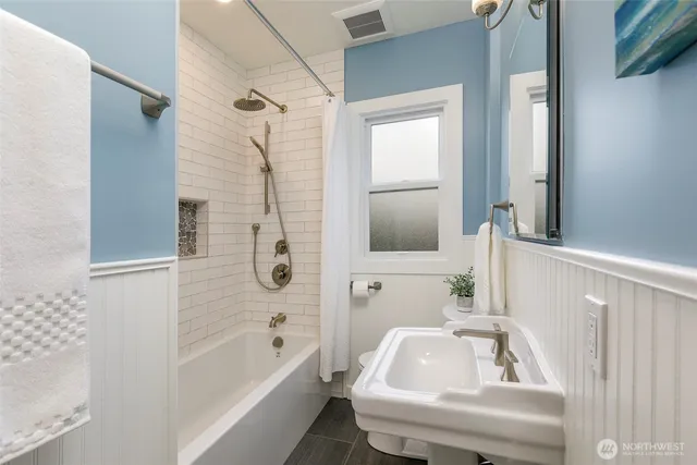 a bathroom with a tub a sink and a large mirror