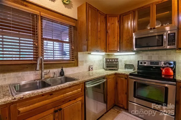 a kitchen with stainless steel appliances a stove a sink and a microwave