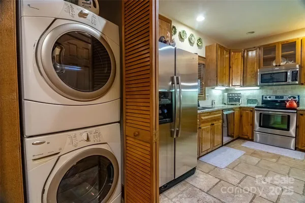 a kitchen with stainless steel appliances granite countertop a refrigerator a washer and dryer
