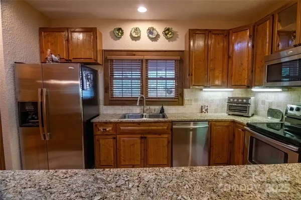 a kitchen with stainless steel appliances granite countertop a sink stove and refrigerator