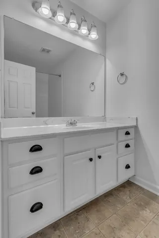 a bathroom with a sink vanity and mirror