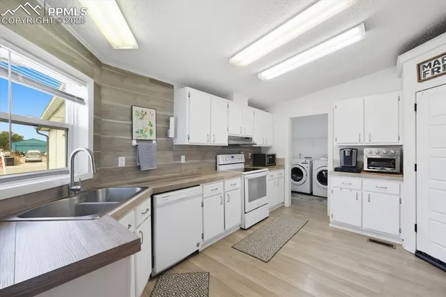 a kitchen with white cabinets sink and appliances