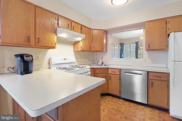 a kitchen with stainless steel appliances a stove refrigerator sink and cabinets