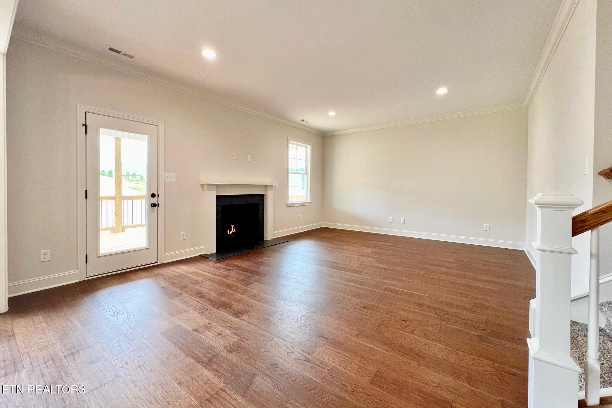 1209 Madison Oaks Road Knoxville, TN 37924 - Photo 12 of 35 an empty room with wooden floor fireplace and windows
