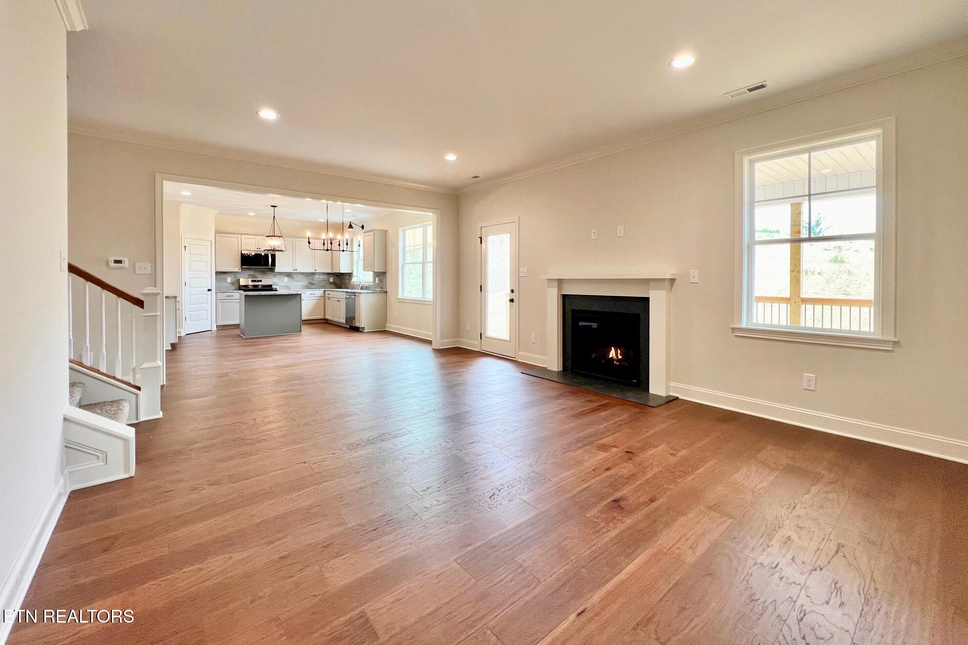 1209 Madison Oaks Road Knoxville, TN 37924 - Photo 13 of 35 an empty room with wooden floor fireplace and windows