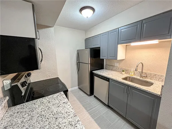 a kitchen with a sink and stainless steel appliances