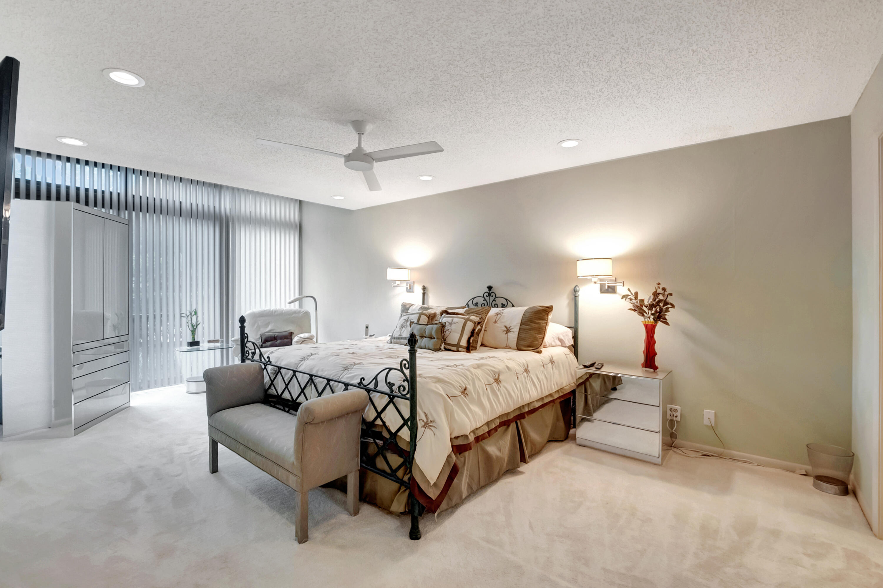 6805 Willow Wood Drive, Unit 5014 Boca Raton, FL 33434 - Photo 24 of 51 a spacious bedroom with a bed and a chandelier