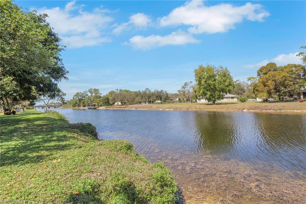 1211 Commonwealth Circle, Unit C201 Naples, FL 34116 - Photo 19 of 23 a view of a lake with houses in the back