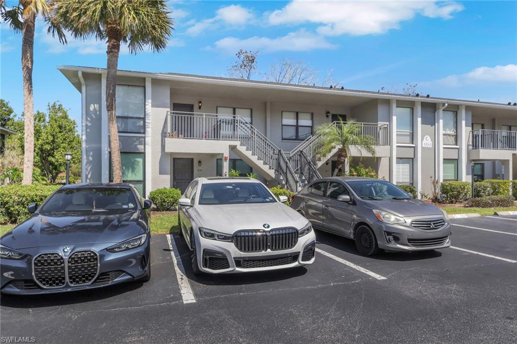 1211 Commonwealth Circle, Unit C201 Naples, FL 34116 - Photo 2 of 23 a couple of cars parked in front of a house
