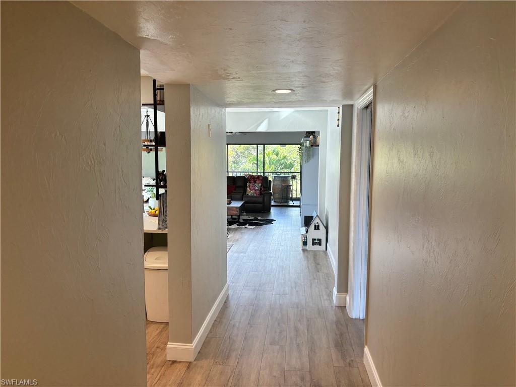 1211 Commonwealth Circle, Unit C201 Naples, FL 34116 - Photo 3 of 23 a view of a hallway with wooden floor and windows