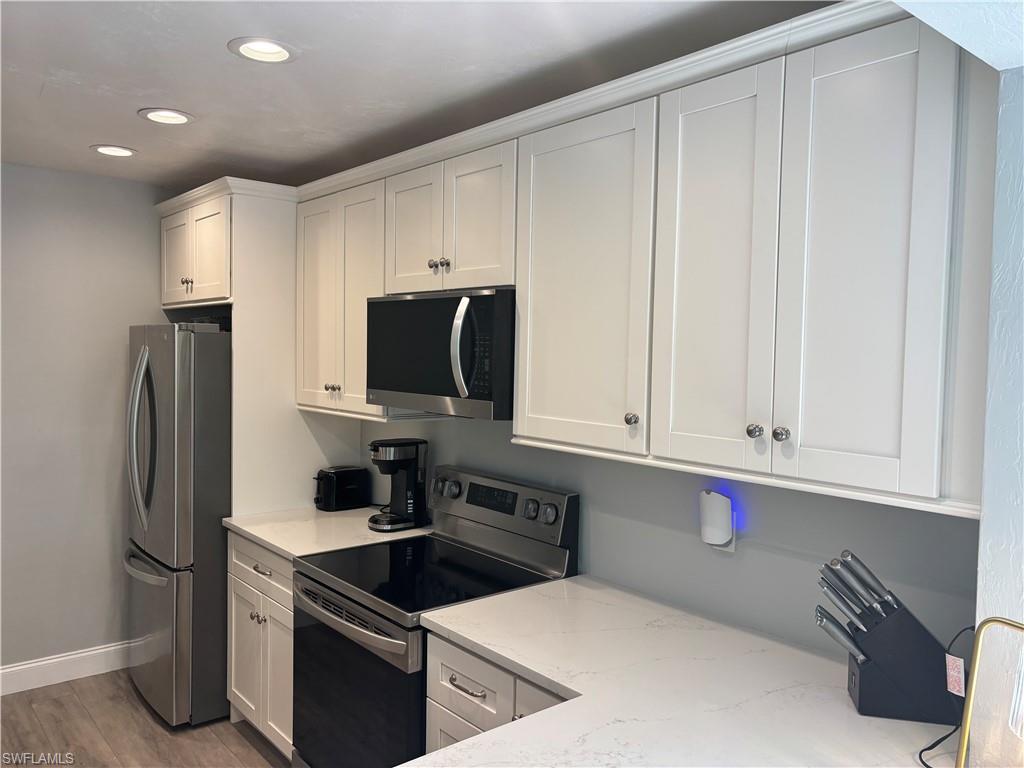 1211 Commonwealth Circle, Unit C201 Naples, FL 34116 - Photo 5 of 23 a kitchen with stainless steel appliances granite countertop a refrigerator and a sink
