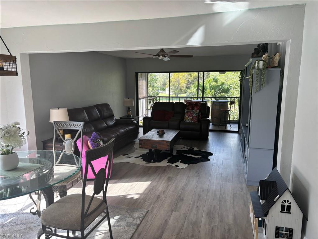 1211 Commonwealth Circle, Unit C201 Naples, FL 34116 - Photo 6 of 23 a living room with furniture floor to ceiling window and wooden floor