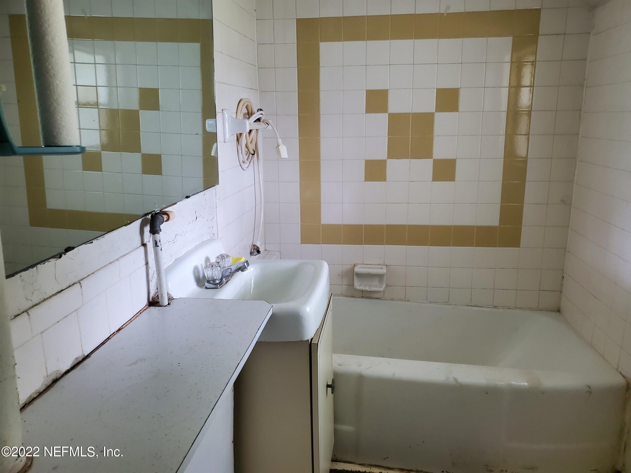 28 Jackson Road Atlantic Beach, FL 32233 - Photo 3 of 7 a bathroom with a bathtub and a sink