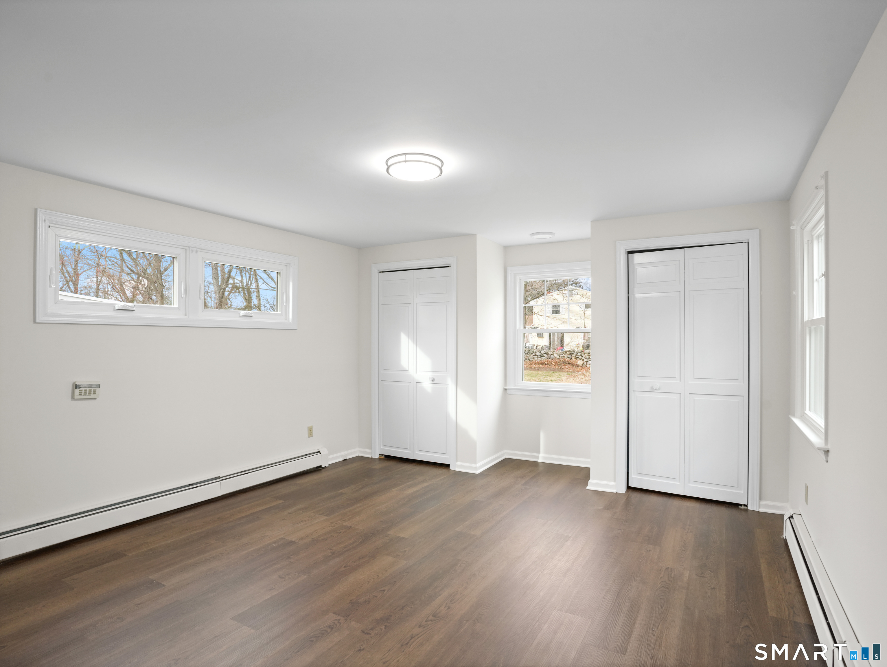 8 Raleigh Road Bridgeport, CT 06606 - Photo 11 of 20 an empty room with wooden floor and windows