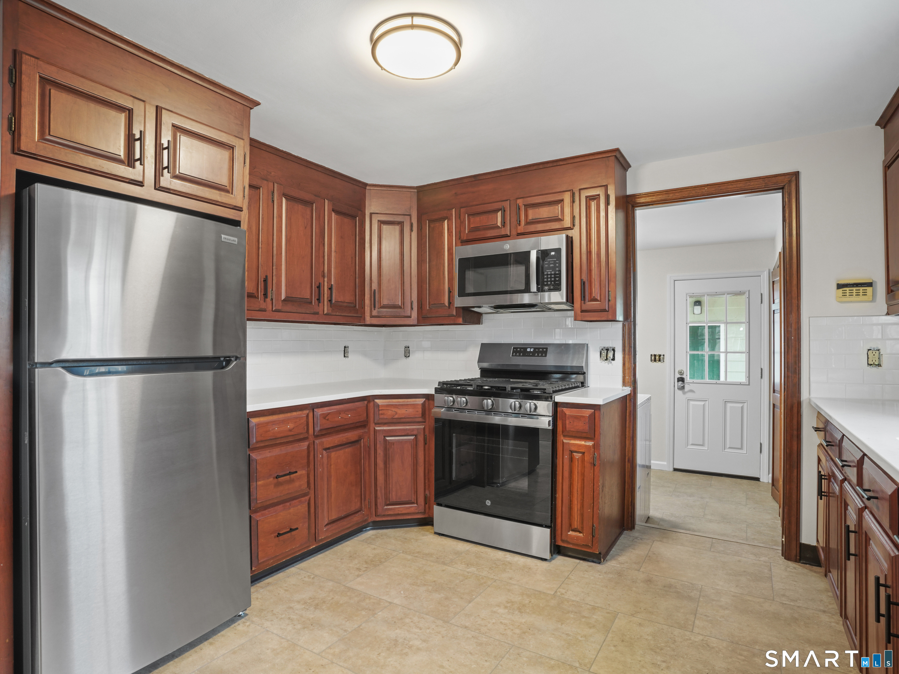 8 Raleigh Road Bridgeport, CT 06606 - Photo 7 of 20 a kitchen with stainless steel appliances granite countertop a refrigerator stove a sink and a microwave