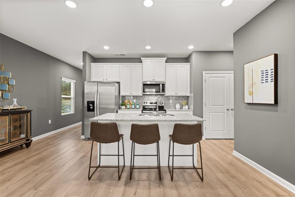 269 Epping Street, Unit 81 Stockbridge, GA 30281 - Photo 14 of 64 a kitchen with stainless steel appliances granite countertop a refrigerator a stove top oven a sink dishwasher and white cabinets with wooden floor