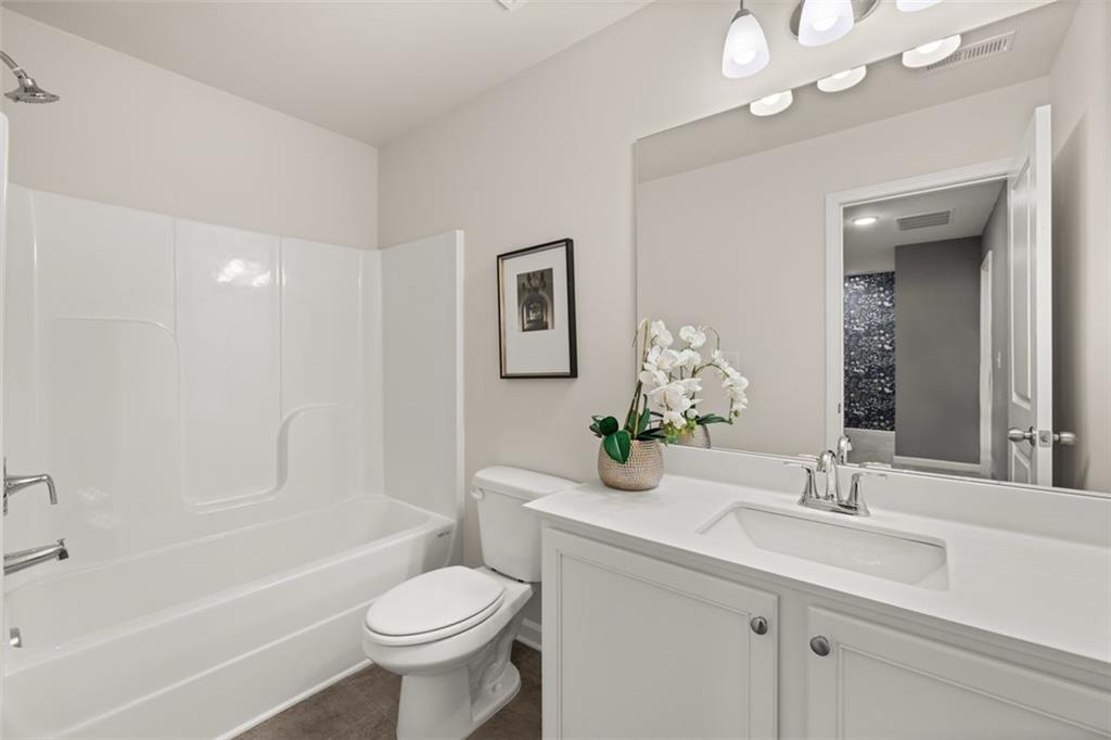 269 Epping Street, Unit 81 Stockbridge, GA 30281 - Photo 57 of 64 a bathroom with a toilet a sink a mirror a bathtub and vanity