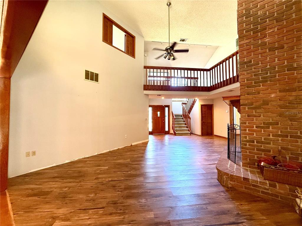 2395 Windward Cove Kissimmee, FL 34746 - Photo 11 of 62 a view of a livingroom with hardwood floor and staircase