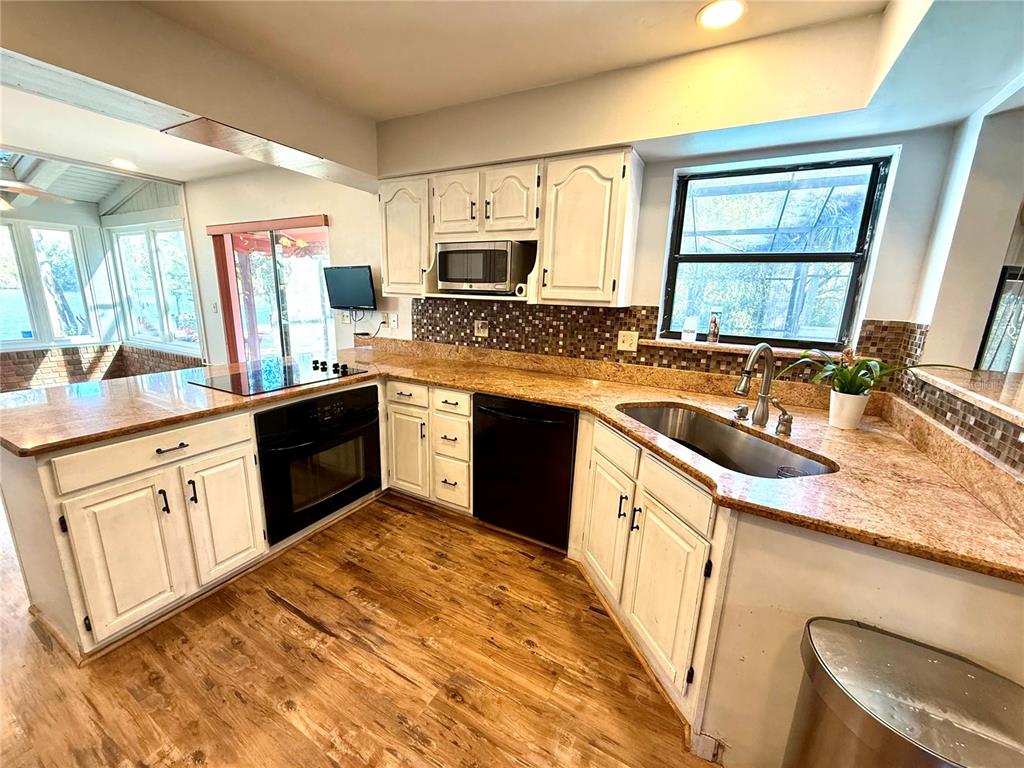 2395 Windward Cove Kissimmee, FL 34746 - Photo 12 of 62 a kitchen with stainless steel appliances granite countertop a sink stove microwave and refrigerator