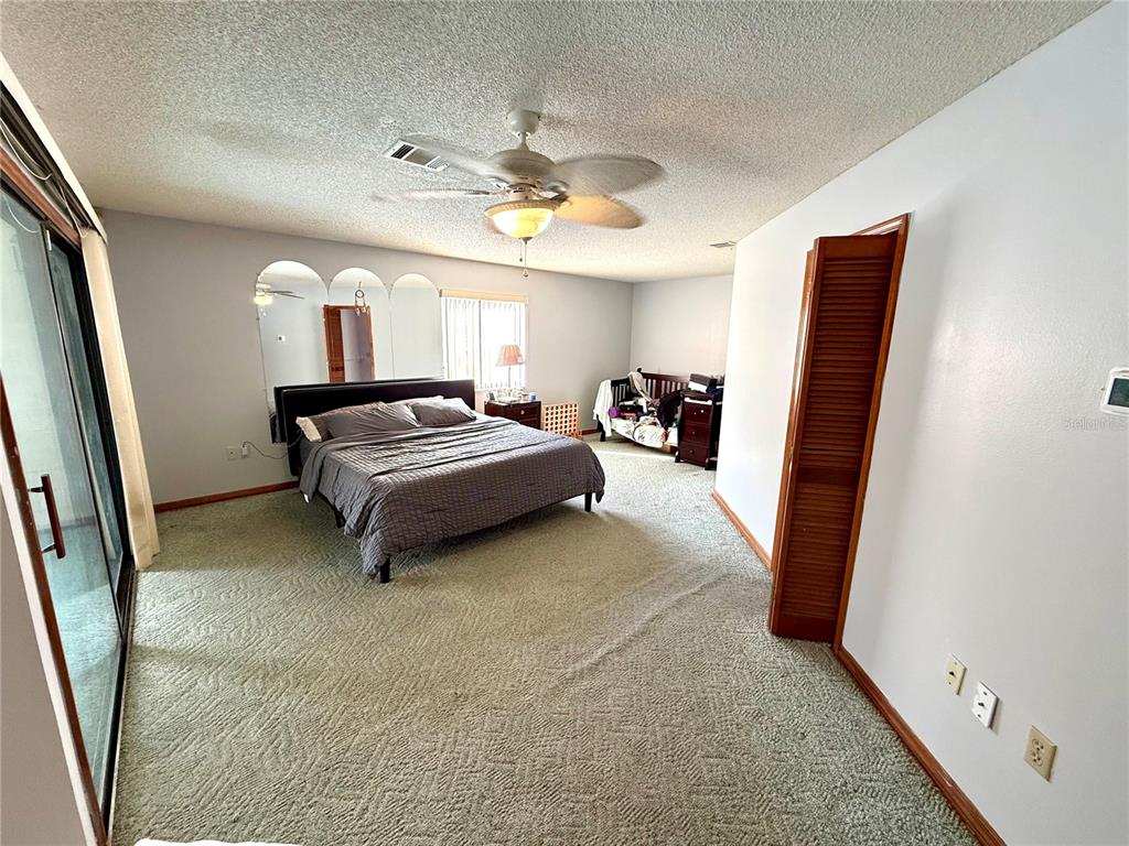 2395 Windward Cove Kissimmee, FL 34746 - Photo 25 of 62 a bedroom with a bed and a large mirror on the dresser