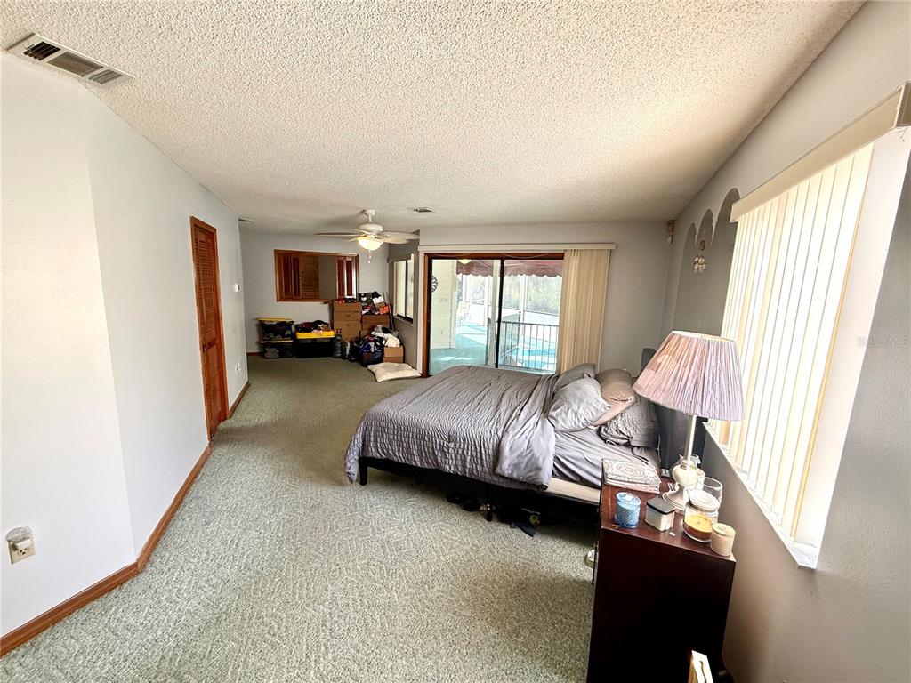 2395 Windward Cove Kissimmee, FL 34746 - Photo 26 of 62 a spacious bedroom with a bed couch and window