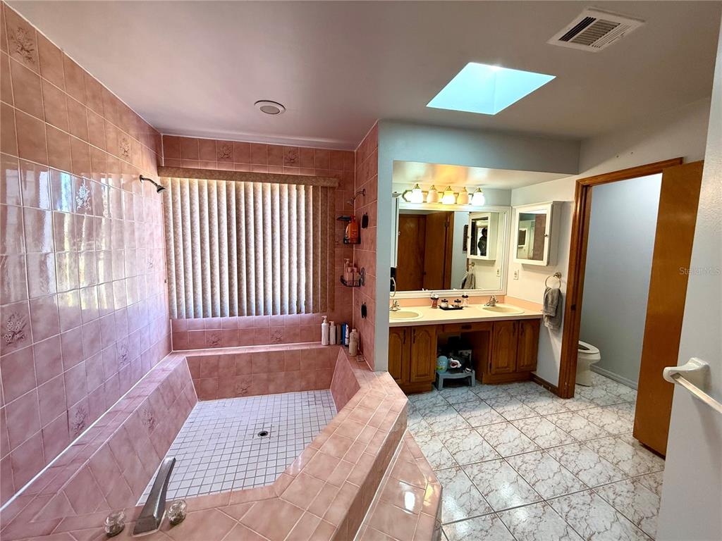 2395 Windward Cove Kissimmee, FL 34746 - Photo 27 of 62 a large bathroom with a tub sink and mirror