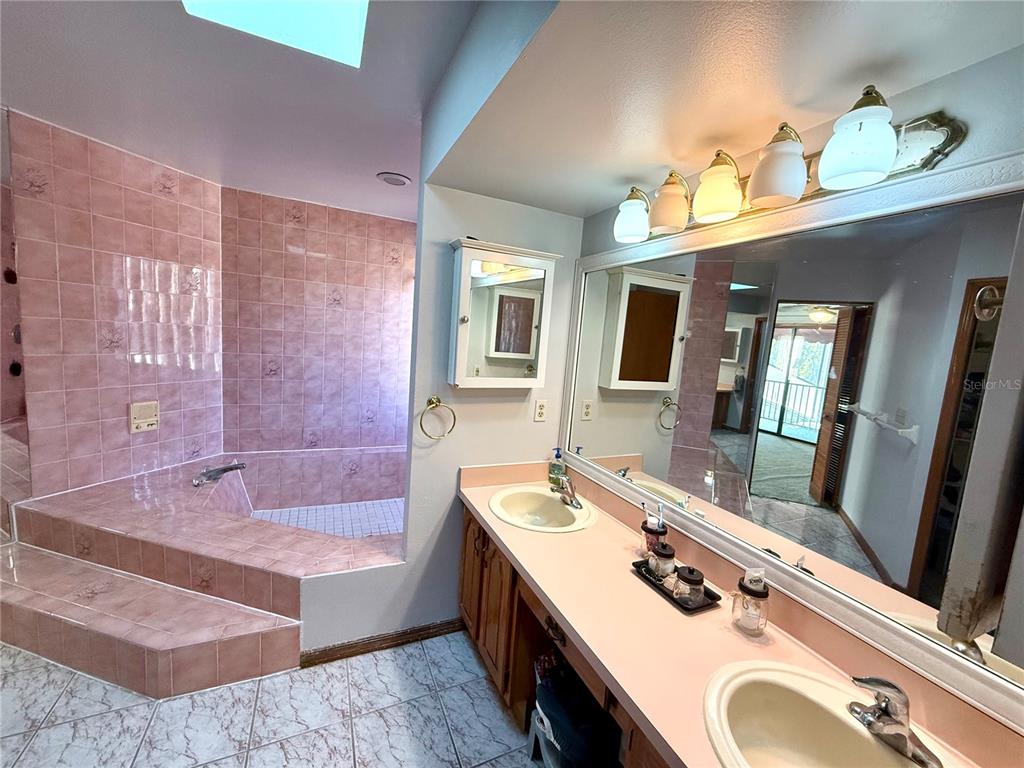 2395 Windward Cove Kissimmee, FL 34746 - Photo 28 of 62 a bathroom with a tub sink and mirror