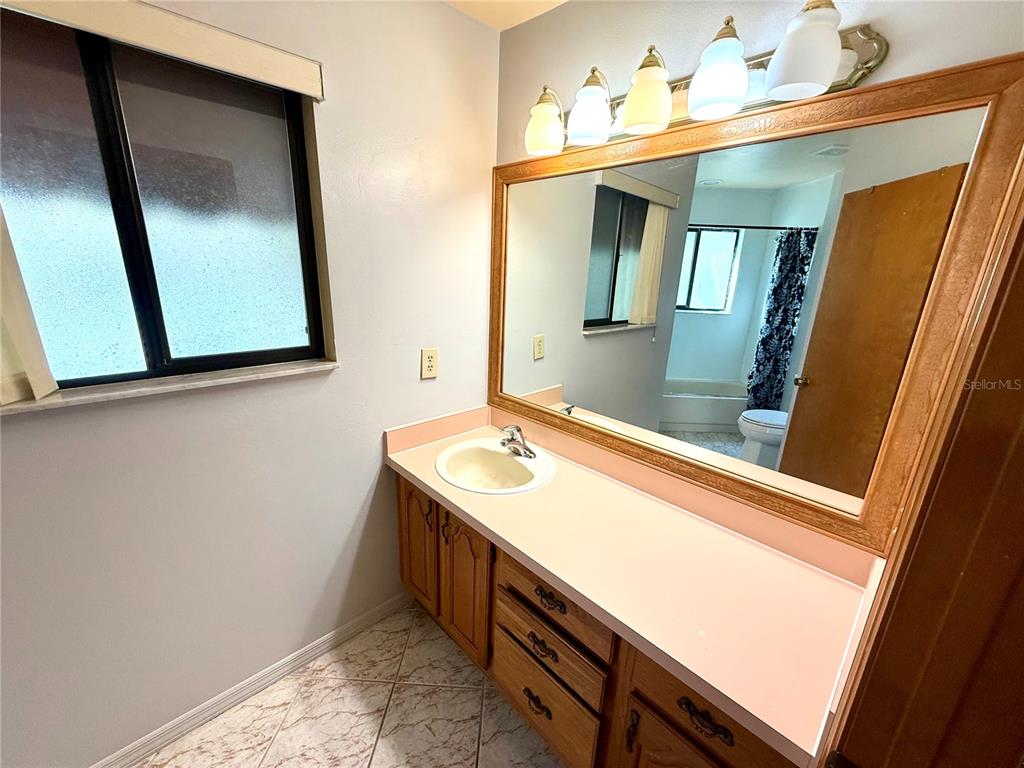 2395 Windward Cove Kissimmee, FL 34746 - Photo 39 of 62 a bathroom with a sink a mirror and vanity