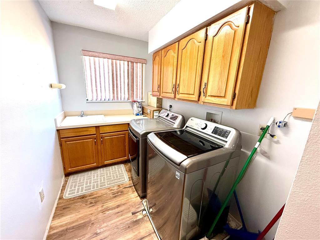 2395 Windward Cove Kissimmee, FL 34746 - Photo 46 of 62 a utility room with a sink a washer and dryer