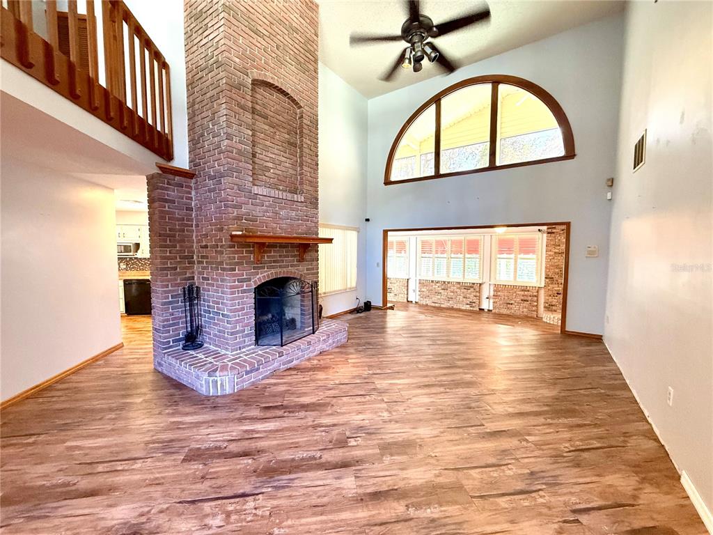 2395 Windward Cove Kissimmee, FL 34746 - Photo 10 of 62 a view of livingroom with fireplace wooden floor and window