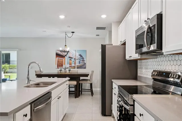 a kitchen with stainless steel appliances granite countertop a sink a stove and a refrigerator