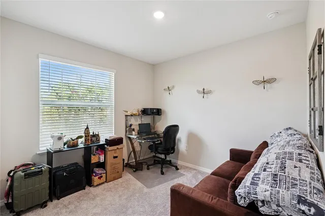 a view of a livingroom with workspace and a window