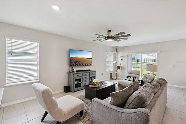 a living room with furniture a large window and a flat screen tv