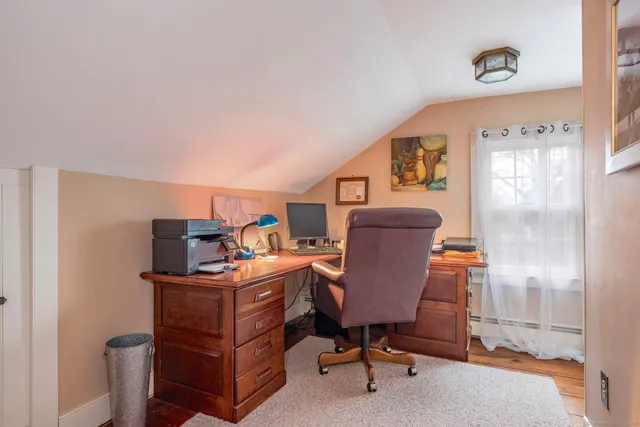 a view of a workspace with furniture and a window
