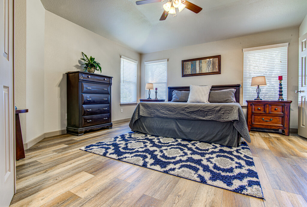 7712 Earp Way Austin, TX 78729 - Photo 19 of 40 a bedroom with a bed and a chandelier