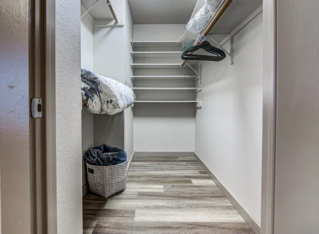 a view of walk in closet with clothes and shoes