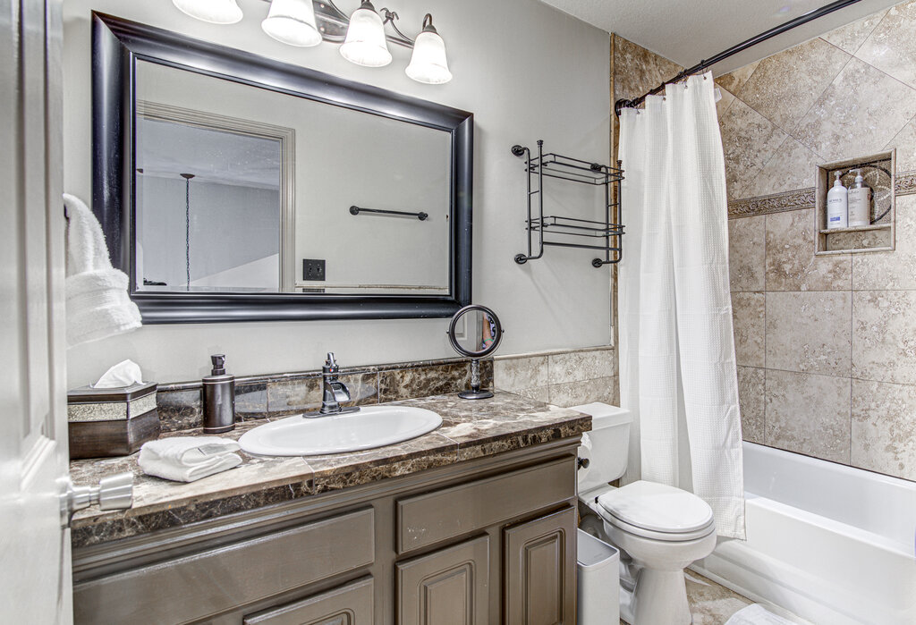 7712 Earp Way Austin, TX 78729 - Photo 29 of 40 a bathroom with a granite countertop sink toilet and shower