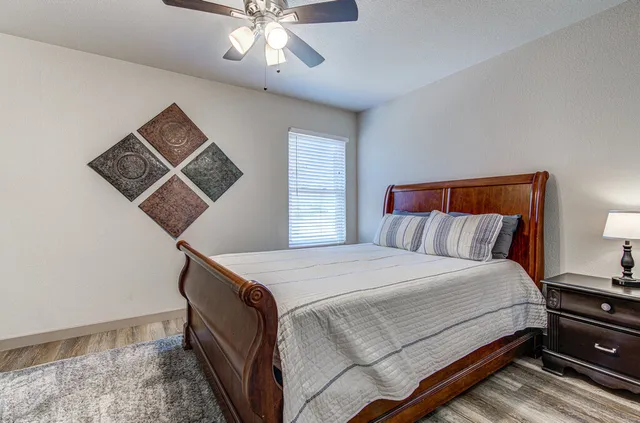 a bedroom with a bed and a lamp on dresser