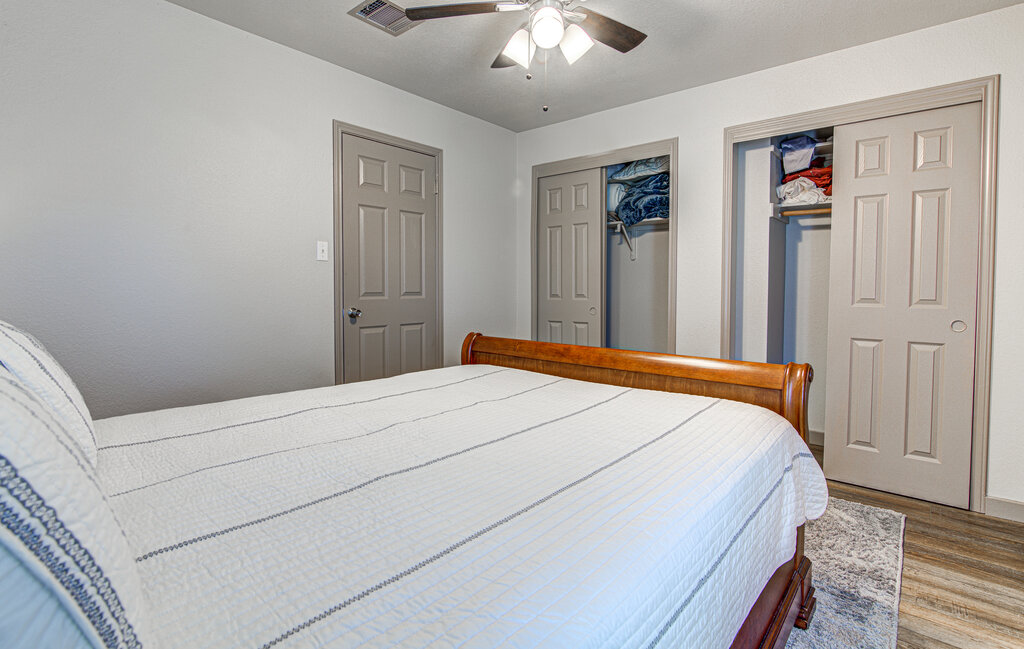 7712 Earp Way Austin, TX 78729 - Photo 32 of 40 a bedroom with a large bed and a chandelier