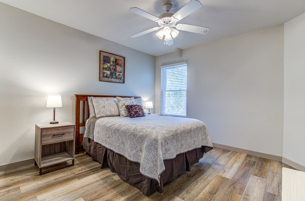 7712 Earp Way Austin, TX 78729 - Photo 33 of 40 a bedroom with a bed and a chandelier