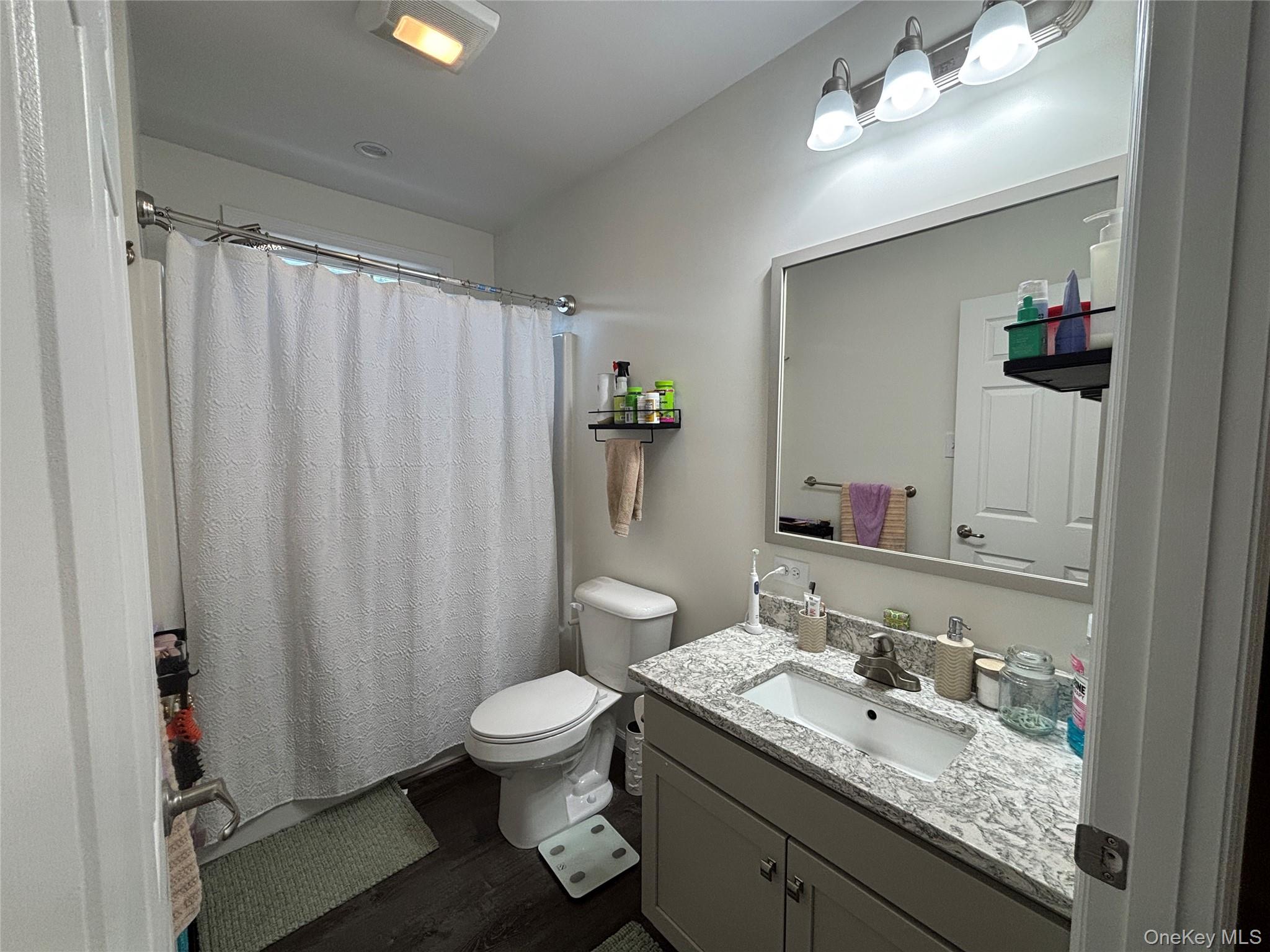 1661 Old Country Road, Unit 563 Riverhead, NY 11901 - Photo 17 of 43 a bathroom with a granite countertop sink toilet and shower