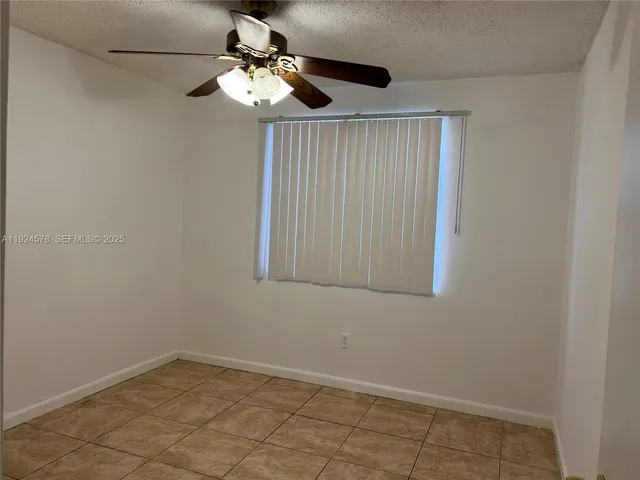 an empty room with a chandelier fan