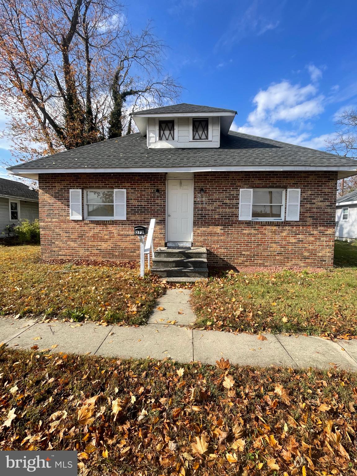 Charming brick home with autumn leaves.