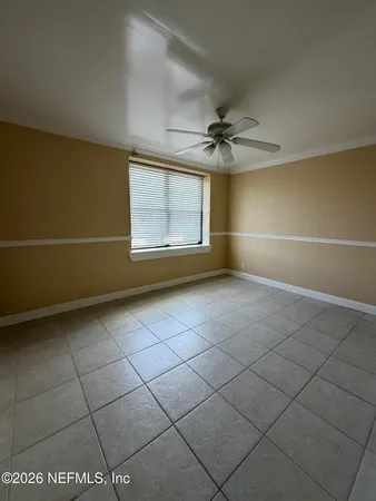 an empty room with windows and fan